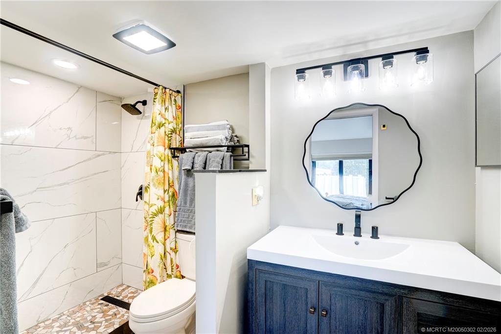 331 Golfview Circle Stuart, FL 34996 - Photo 24 of 48 a bathroom with a sink mirror toilet and shower