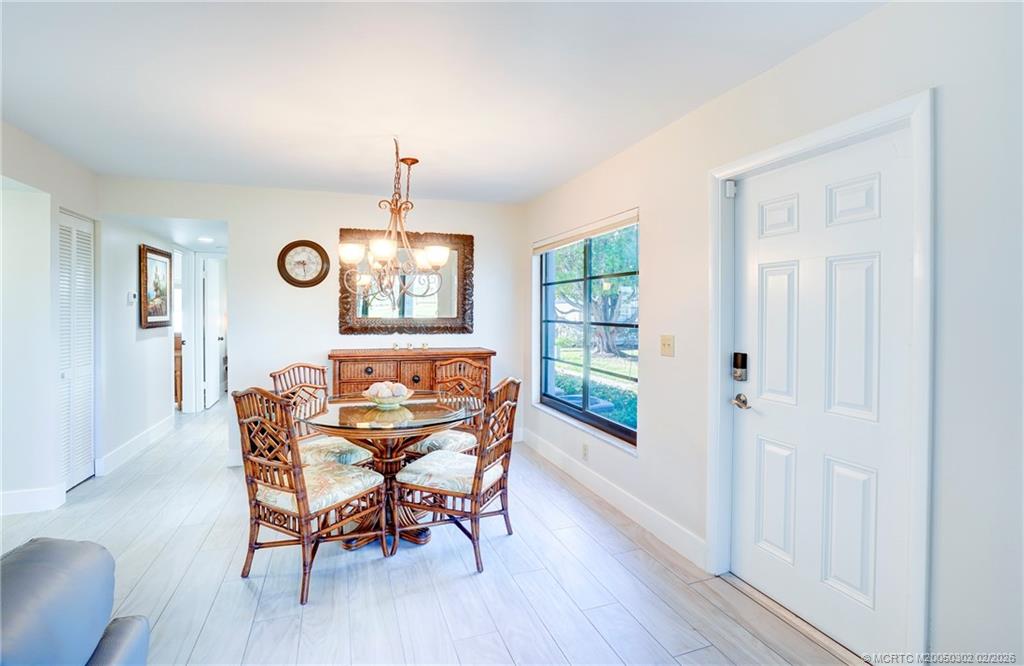 331 Golfview Circle Stuart, FL 34996 - Photo 33 of 48 a dining room with furniture a chandelier and wooden floor