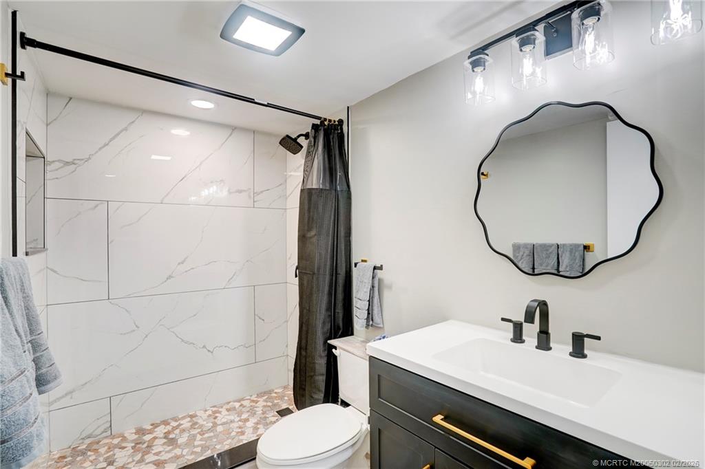 331 Golfview Circle Stuart, FL 34996 - Photo 40 of 48 a bathroom with a sink mirror toilet and shower