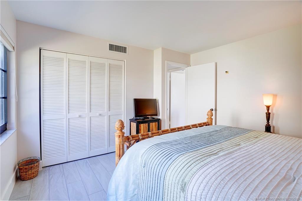 331 Golfview Circle Stuart, FL 34996 - Photo 44 of 48 a bedroom with a bed and a flat tv screen