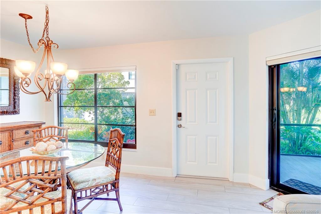 331 Golfview Circle Stuart, FL 34996 - Photo 9 of 48 a dining room with wooden floor wooden floor and windows