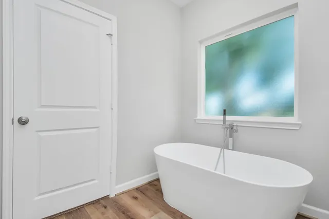 wooden floor in an empty room with a window