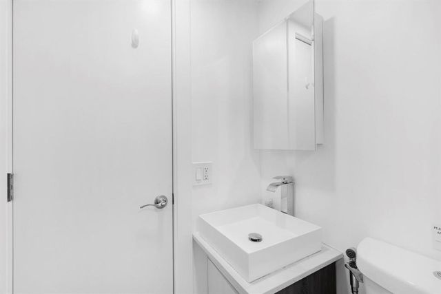 a white bed sitting in a bedroom next to a window