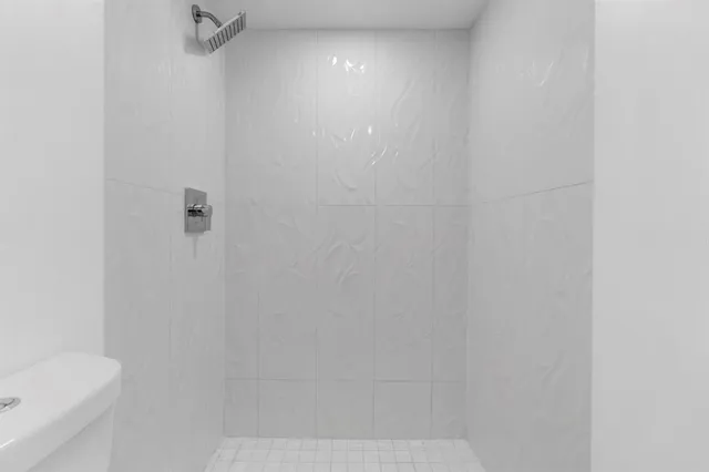 a bedroom with a bed and a white wall