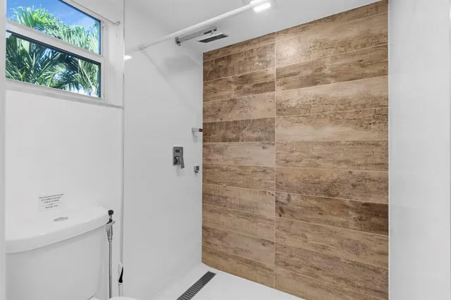 a view of empty room with kitchen and window