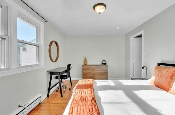 a bedroom with a bed and wooden floor