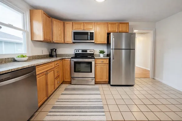 a kitchen with stainless steel appliances granite countertop a refrigerator sink stove microwave and cabinets