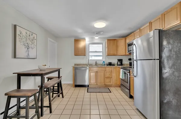 a kitchen with a refrigerator a table and chairs in it