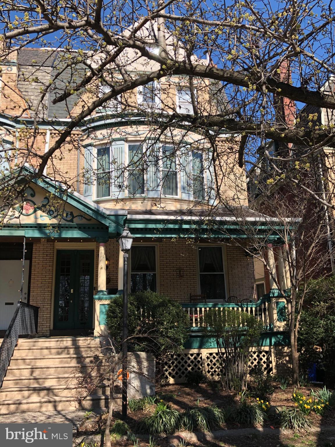 a front view of a house with yard and parking