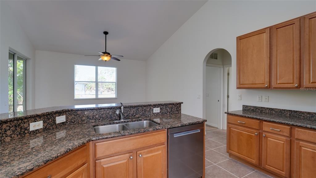 5279 Lovett Road North Port, FL 34288 - Photo 11 of 21 a kitchen with stainless steel appliances granite countertop a sink a window and white cabinets