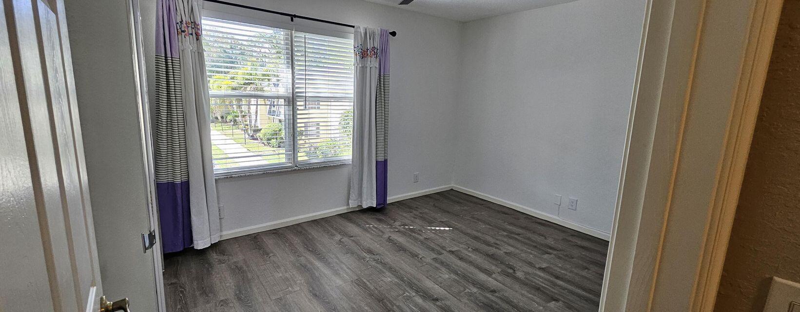 13490 Old Englishtown Road Wellington, FL 33414 - Photo 5 of 13 a view of an empty room with wooden floor and a window
