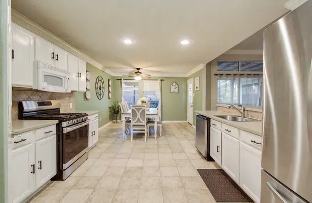 a kitchen with stainless steel appliances granite countertop a stove and a sink