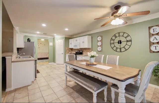 a large kitchen with a table chairs and a refrigerator