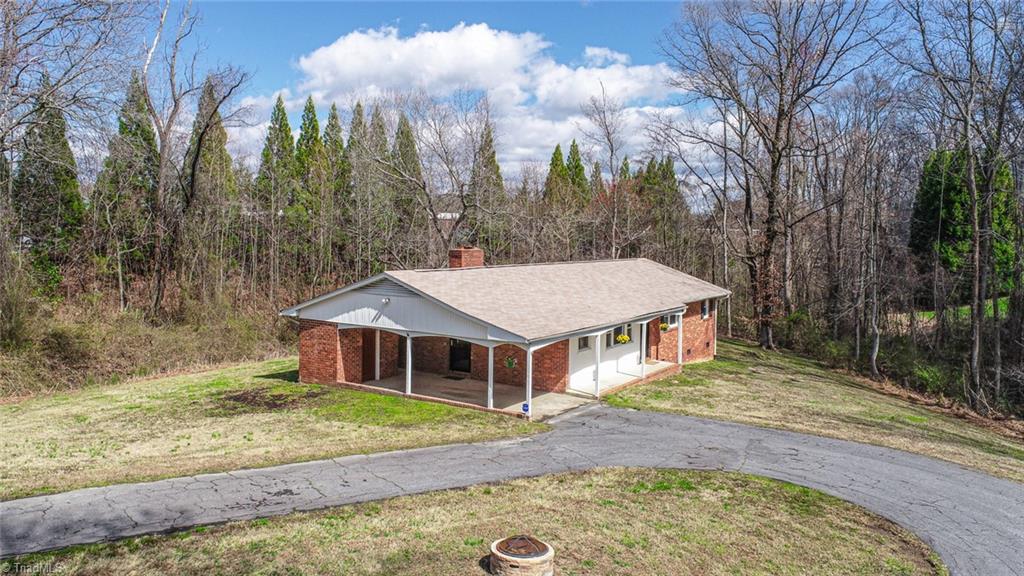 8302 Cadet Drive Oak Ridge, NC 27310 - Photo 1 of 42 8302 Cadet has a circular paved drive with a carport and spacious storage room.