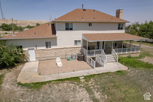 190 600 North Ferron, UT 84523 - Photo 77 of 85 Rear view of house with a chimney, brick siding, covered porch, and a shingled roof