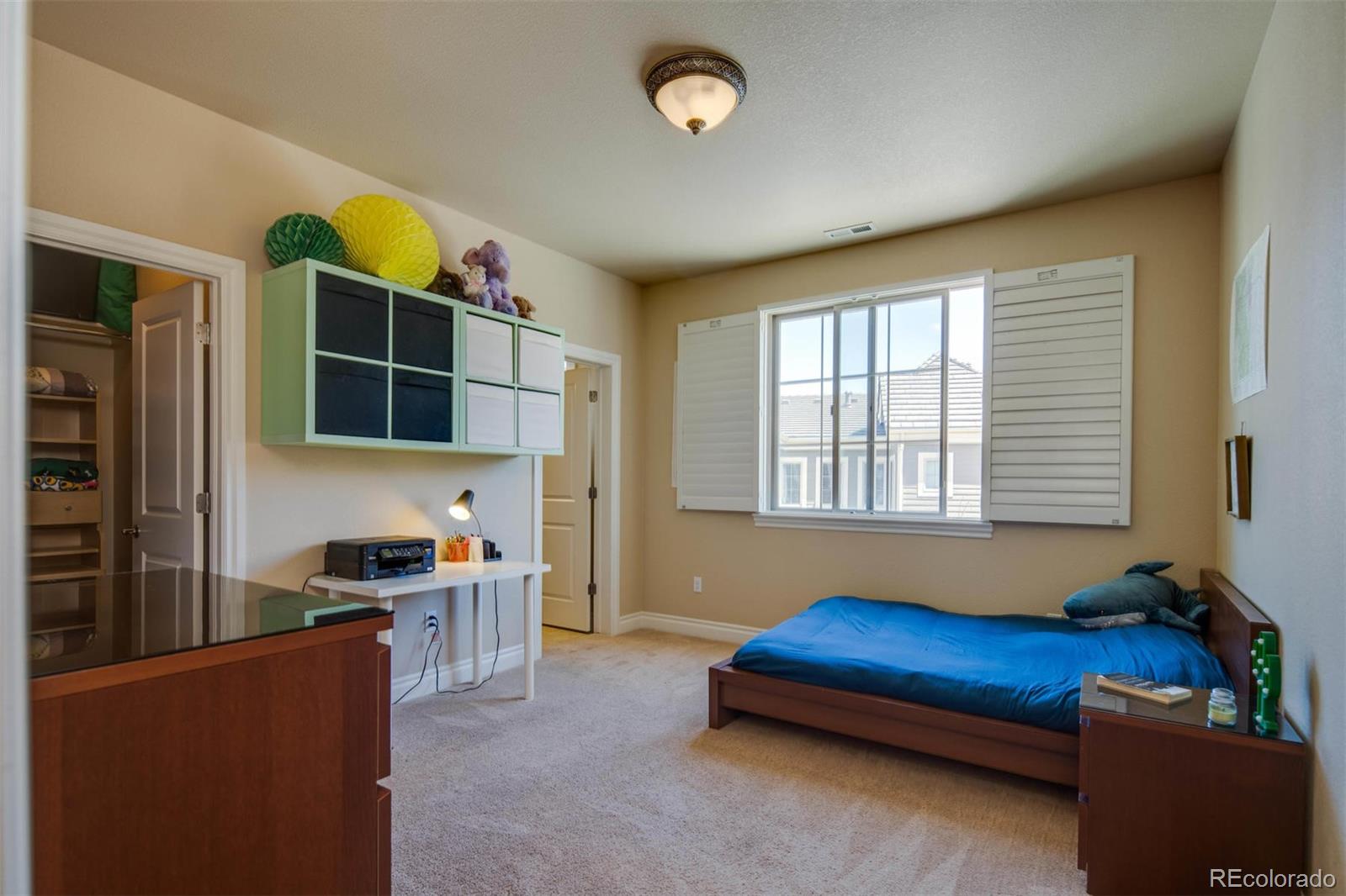 10122 RidgeGate Circle Lone Tree, CO 80124 - Photo 19 of 31 a blue bed sitting in a living room next to a window