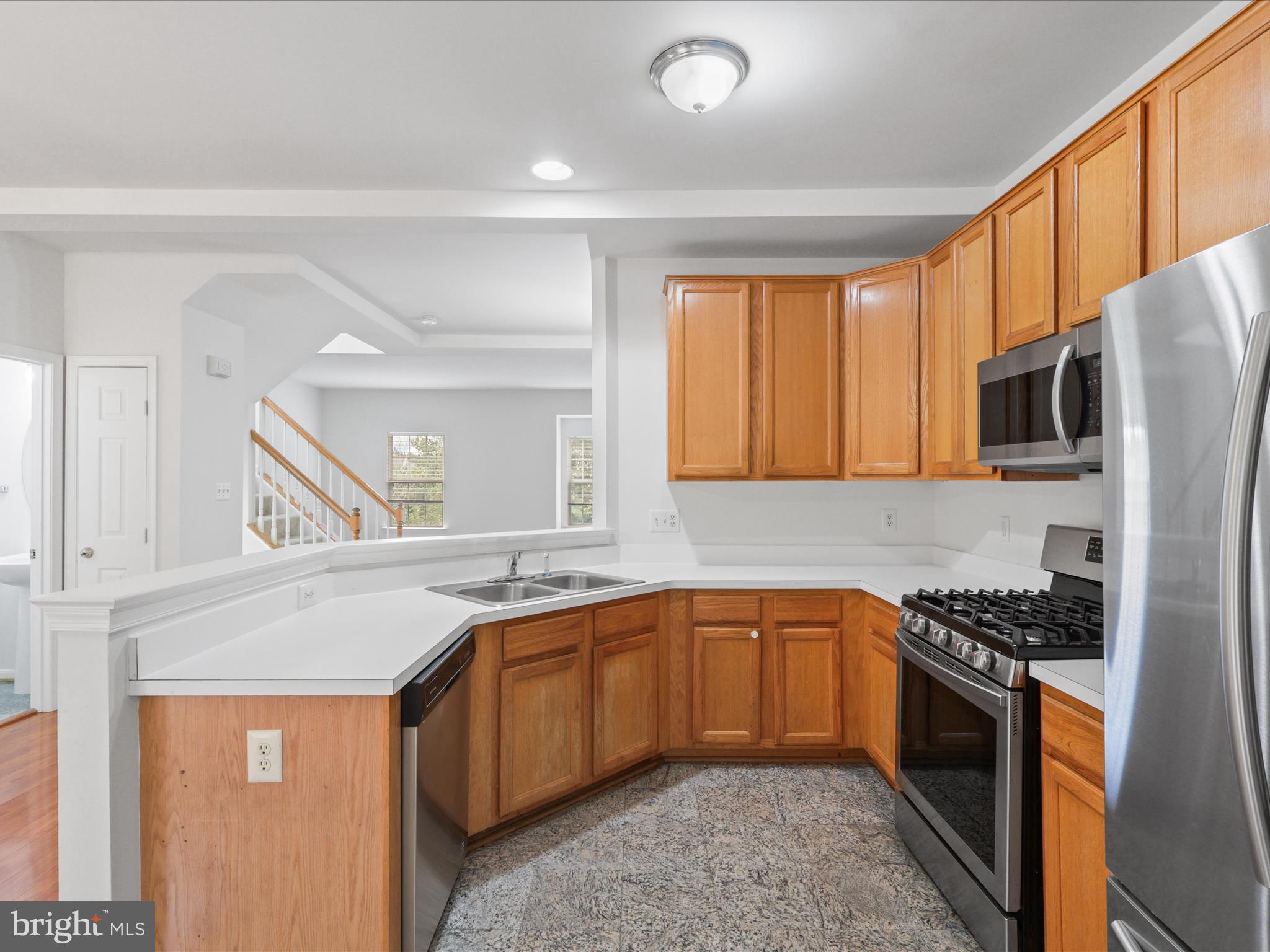 7700 Shadowcreek Terrace Springfield, VA 22153 - Photo 11 of 44 a kitchen with stainless steel appliances granite countertop a sink stove cabinets and refrigerator