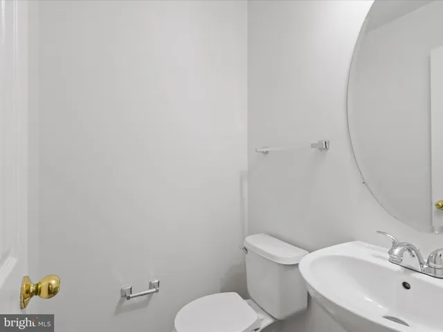 a white toilet sitting next to a white sink and a mirror