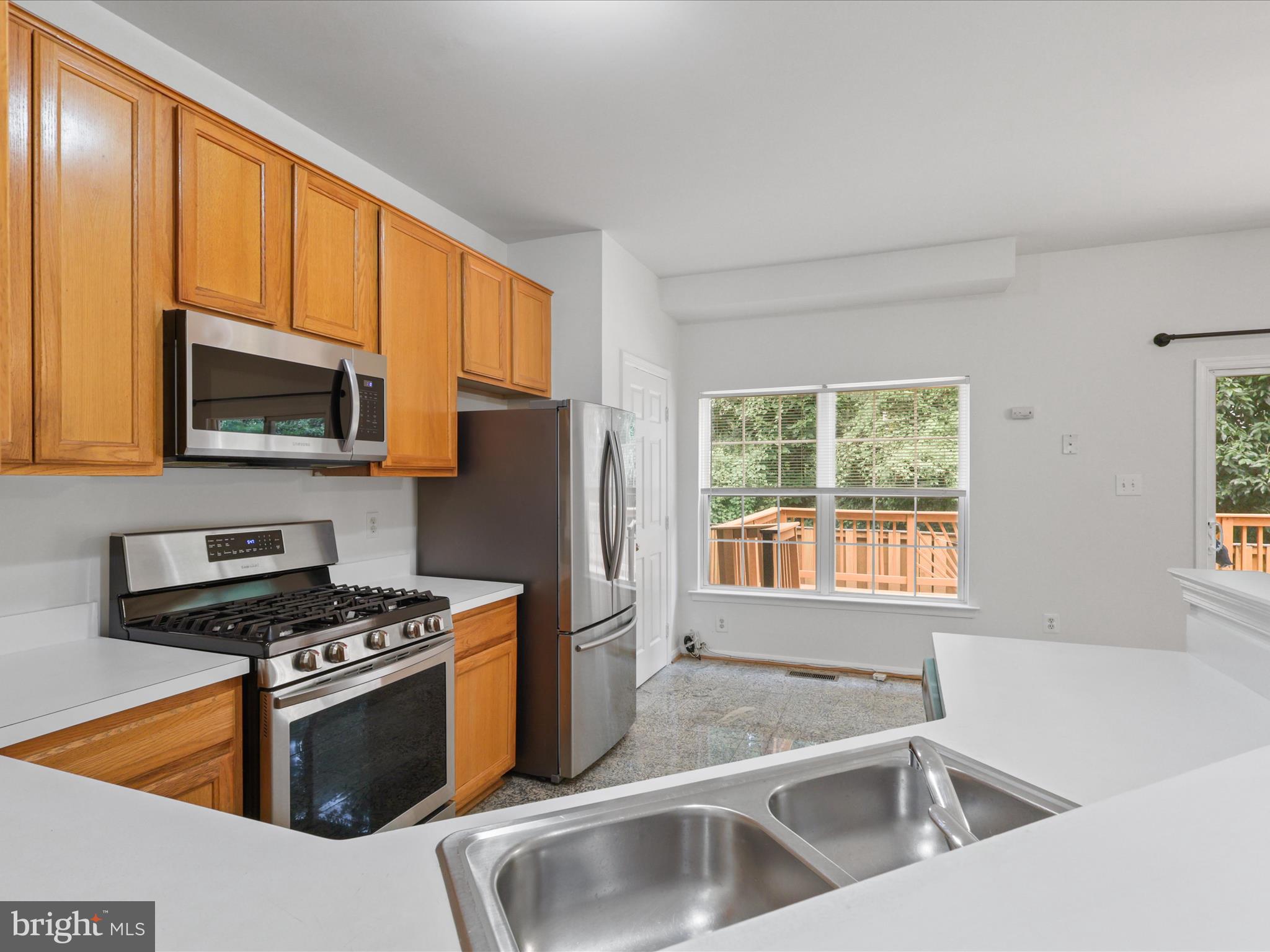 7700 Shadowcreek Terrace Springfield, VA 22153 - Photo 4 of 44 a kitchen with stainless steel appliances granite countertop a stove a sink and a microwave