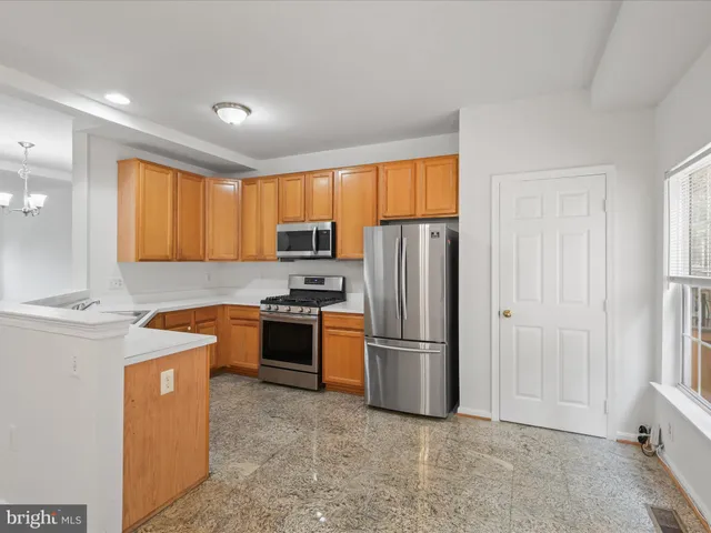 a kitchen with stainless steel appliances granite countertop a refrigerator stove and sink