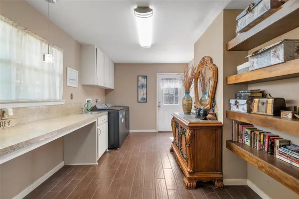 a kitchen with stainless steel appliances granite countertop a refrigerator a sink dishwasher a stove and white countertops with wooden floor