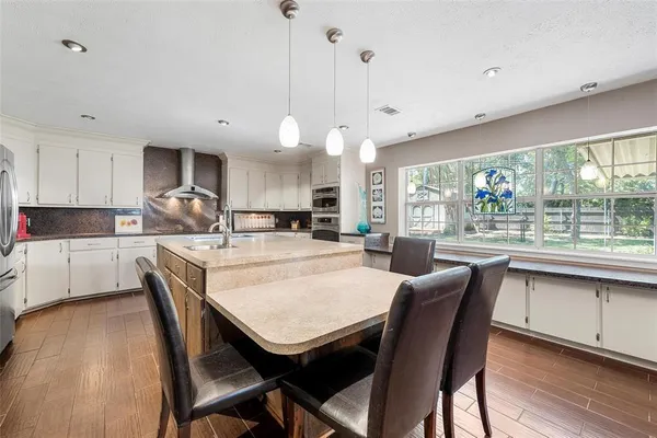 a large kitchen with kitchen island a dining table and chairs