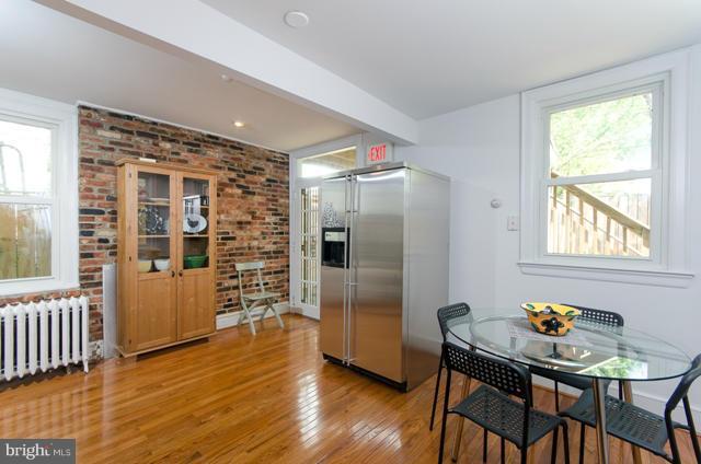 706 E Street Southeast Washington, DC 20003 - Photo 13 of 19 a kitchen with stainless steel appliances wooden floor and dining table