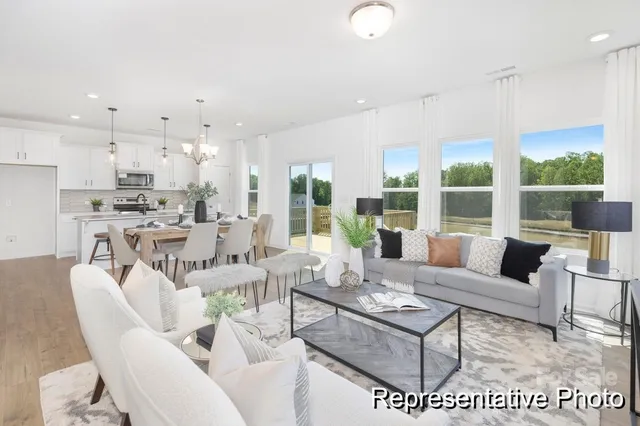 a living room with furniture a large window and a table
