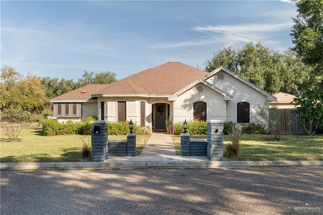 a view of a white house with a yard