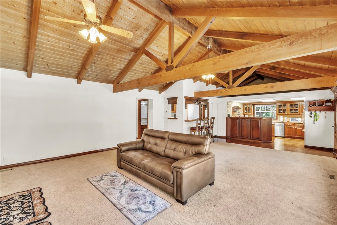 4063 Zugspitz Way Mount Charleston, NV 89124 - Photo 41 of 89 Living area with light carpet, a wood ceiling with exposed beams, ceiling fan, and high vaulted ceiling