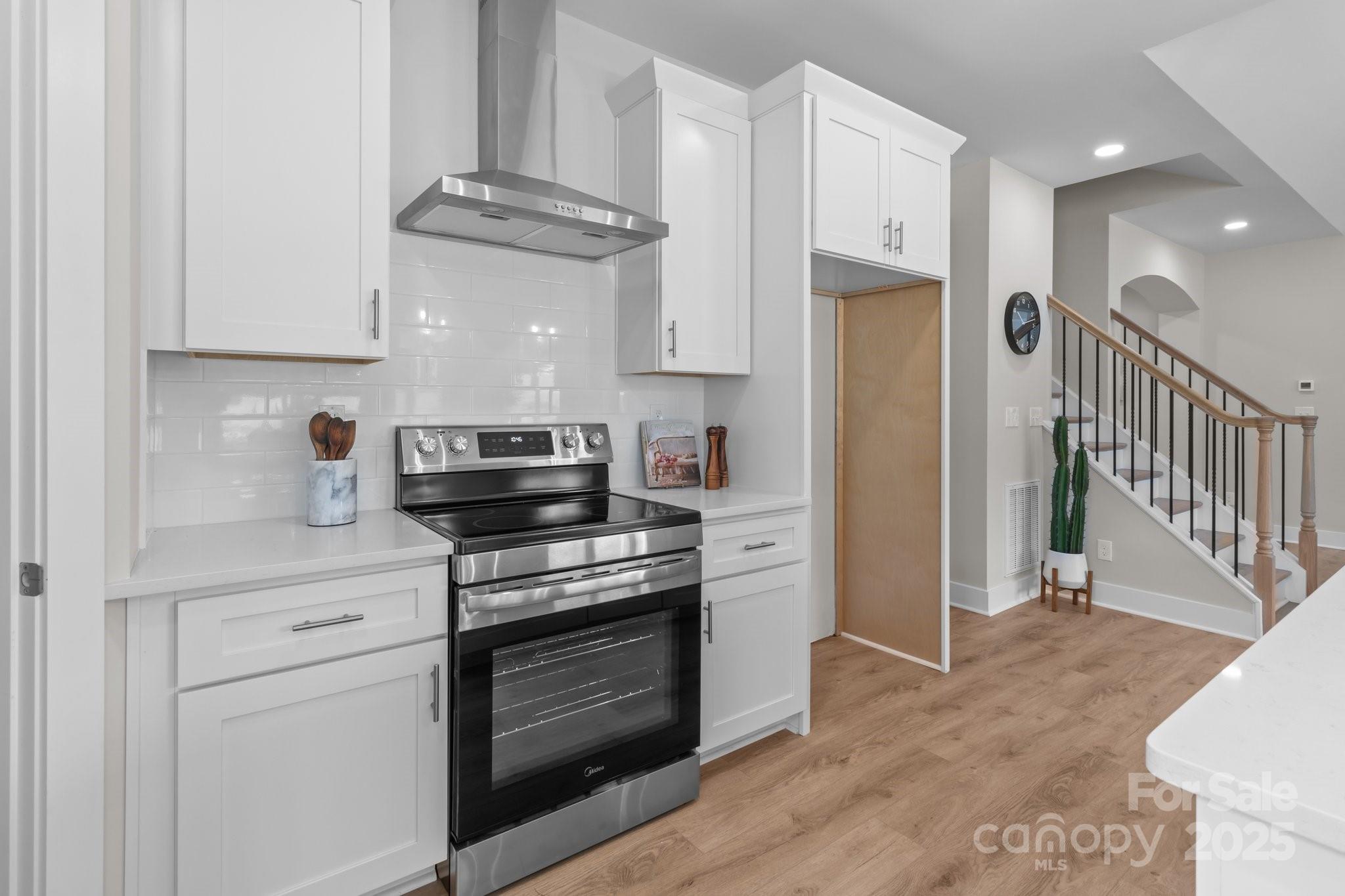 4949 Rimer Road, Unit 4 Concord, NC 28025 - Photo 24 of 46 a kitchen with stainless steel appliances granite countertop a stove a refrigerator and a cabinets with wooden floor