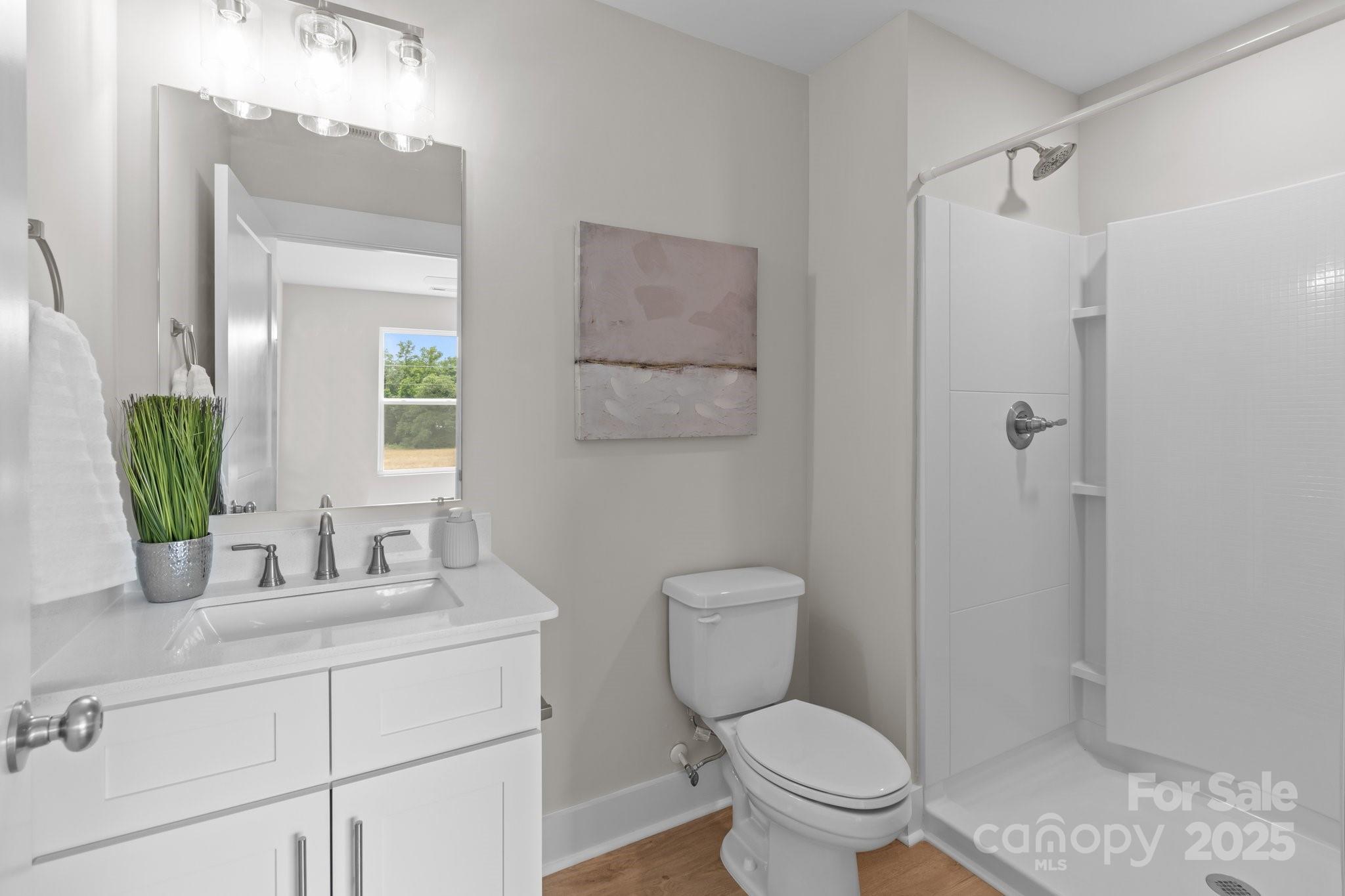 4949 Rimer Road, Unit 4 Concord, NC 28025 - Photo 35 of 46 a bathroom with a toilet sink vanity and mirror