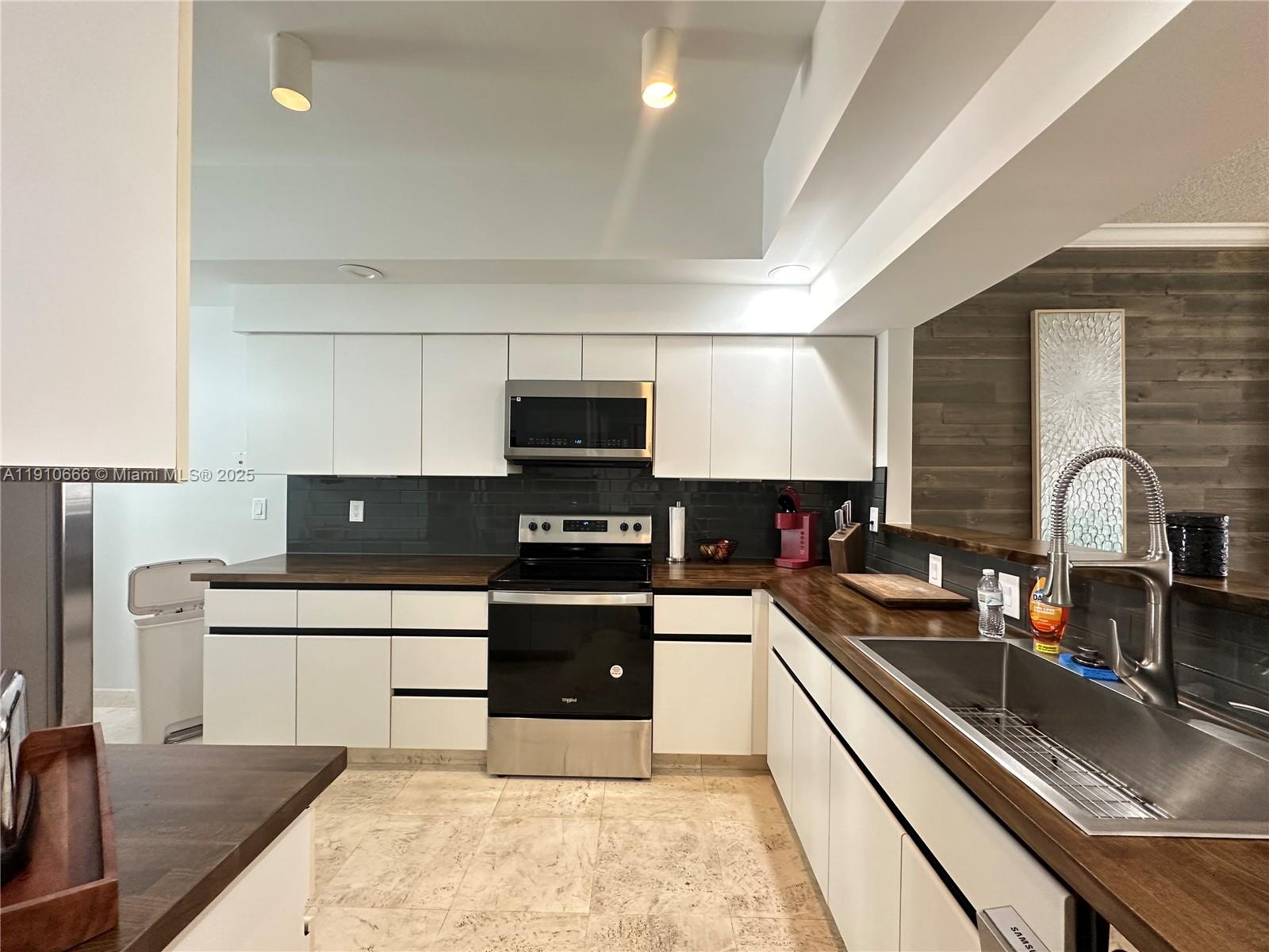 3900 Island Boulevard, Unit B303 Aventura, FL 33160 - Photo 14 of 35 a kitchen with stainless steel appliances a sink a stove top oven a counter space and cabinets