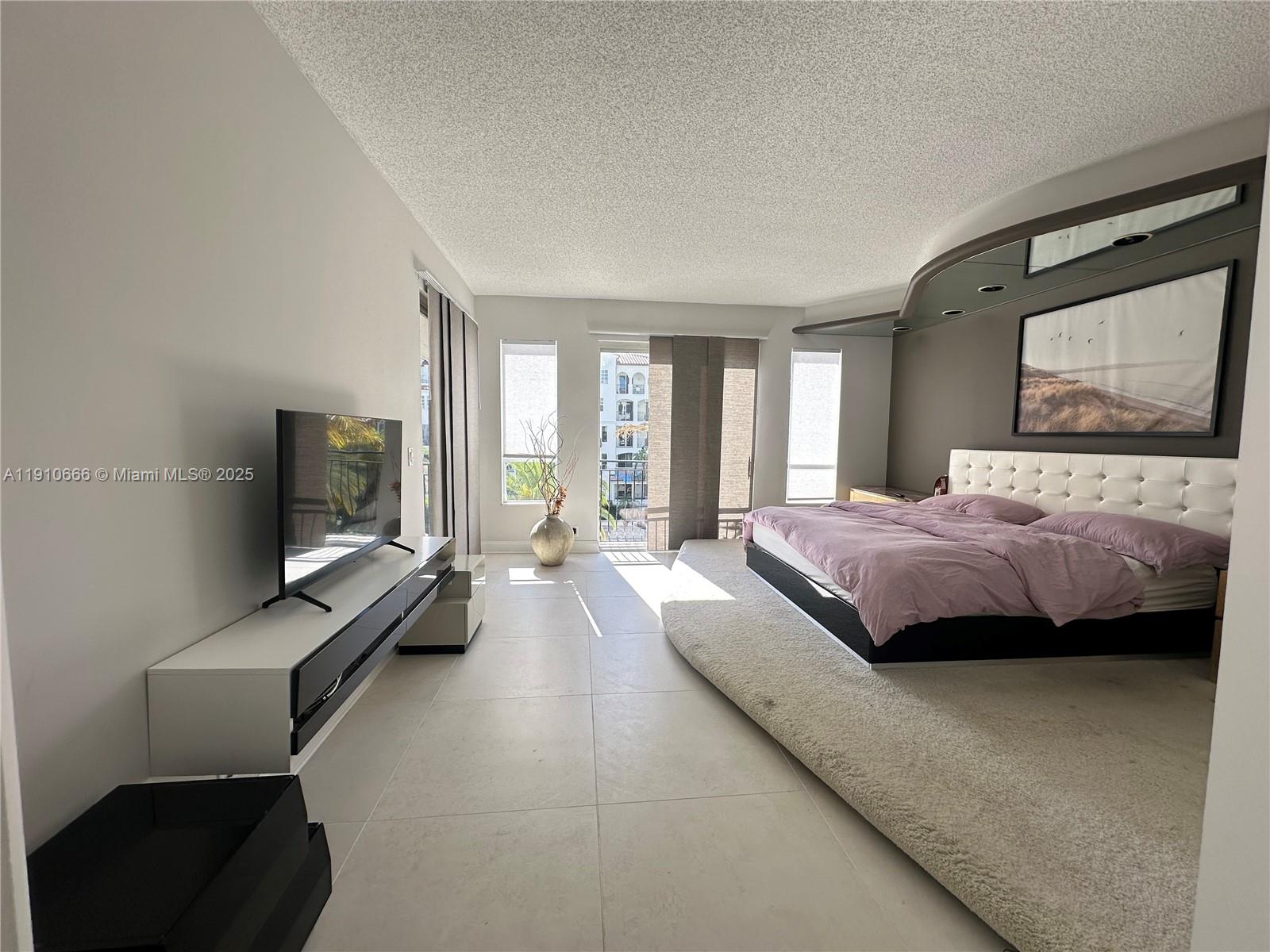 3900 Island Boulevard, Unit B303 Aventura, FL 33160 - Photo 21 of 35 a spacious bedroom with a bed and a flat screen tv