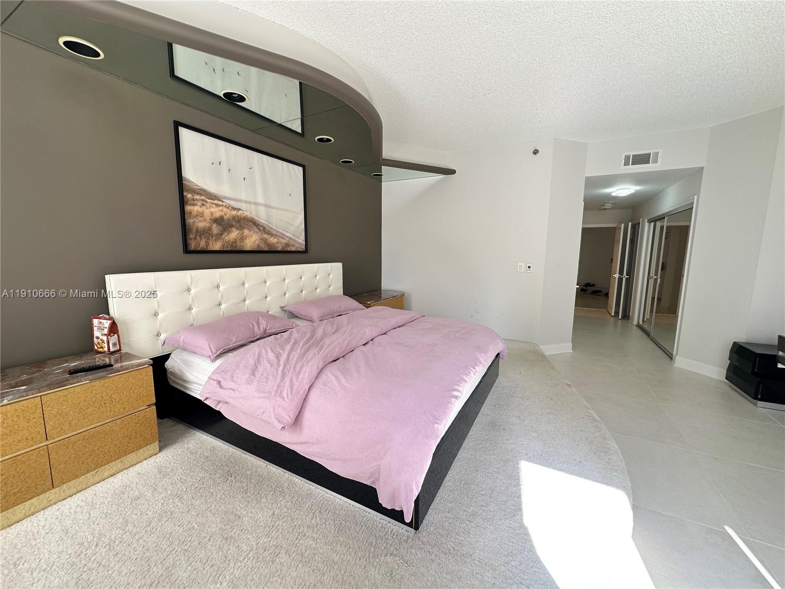 3900 Island Boulevard, Unit B303 Aventura, FL 33160 - Photo 24 of 35 a bedroom with a bed and a television