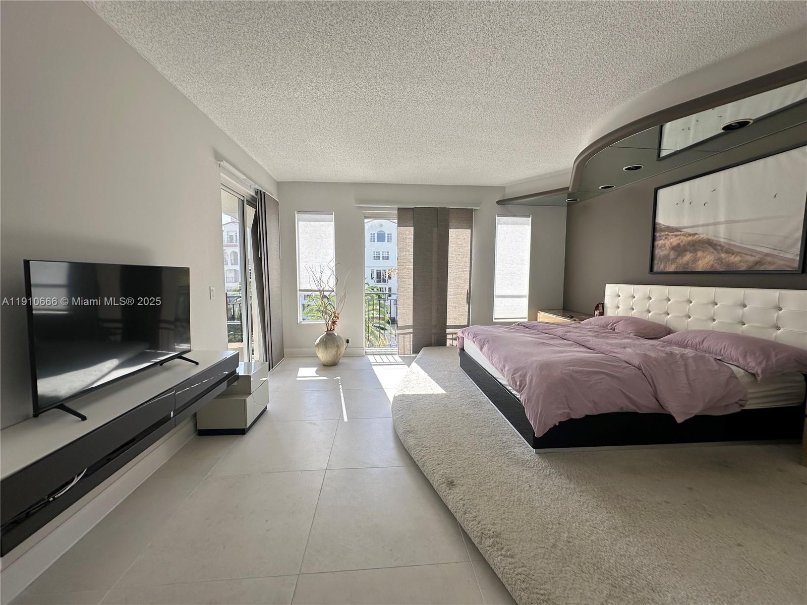 3900 Island Boulevard, Unit B303 Aventura, FL 33160 - Photo 26 of 35 a spacious bedroom with a bed and a flat screen tv