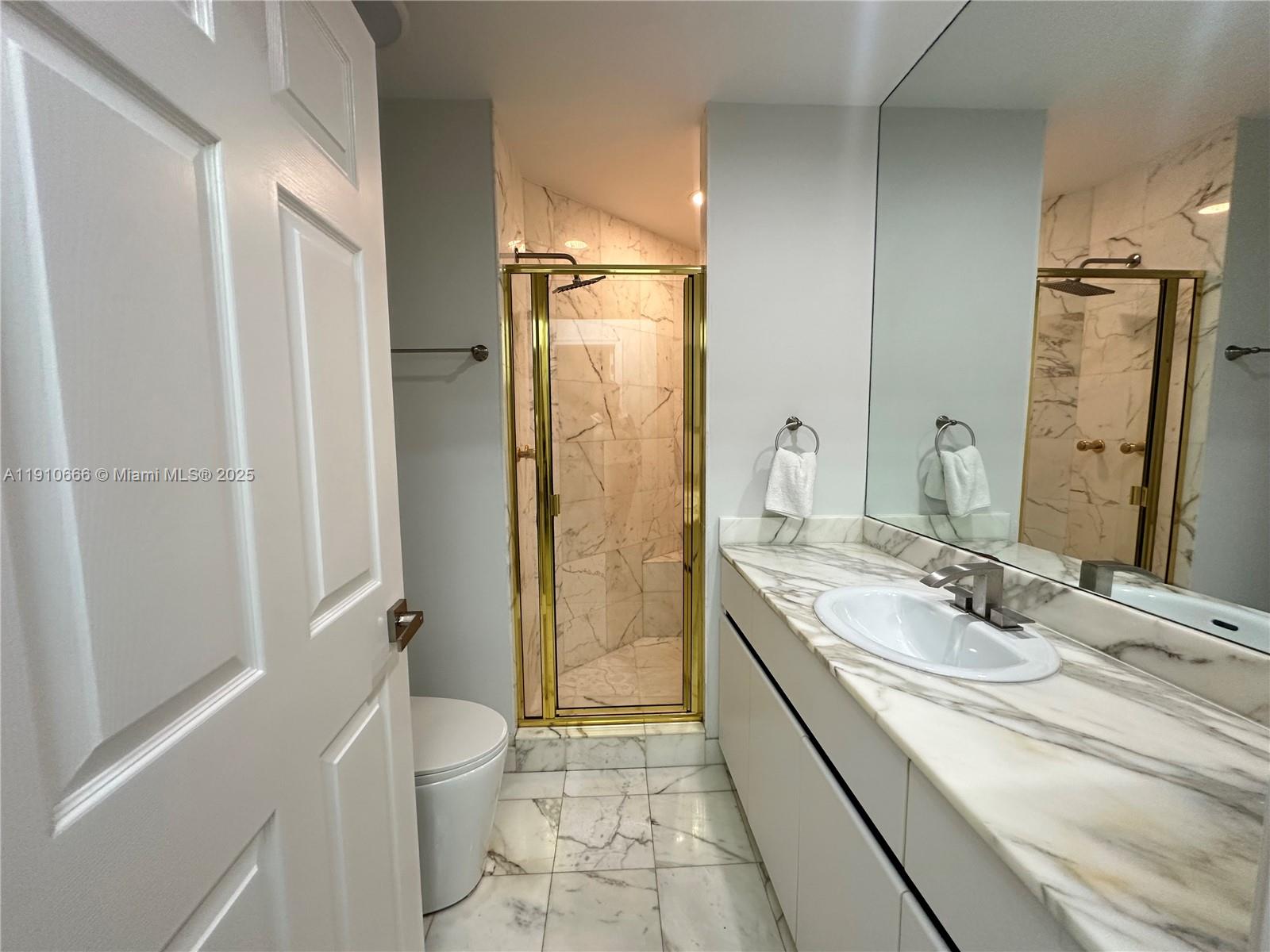 3900 Island Boulevard, Unit B303 Aventura, FL 33160 - Photo 32 of 35 a bathroom with a double vanity sink toilet mirror and shower