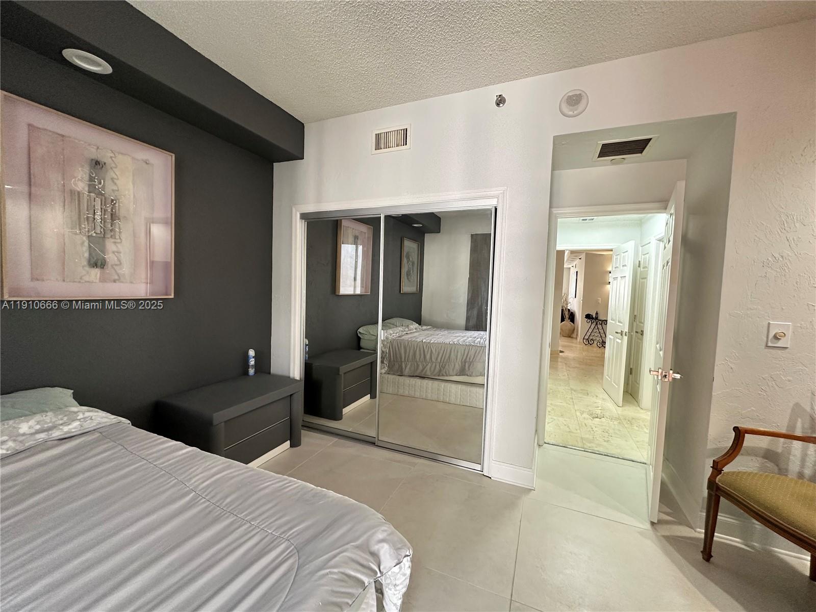 3900 Island Boulevard, Unit B303 Aventura, FL 33160 - Photo 35 of 35 a bedroom with a bed and a mirror