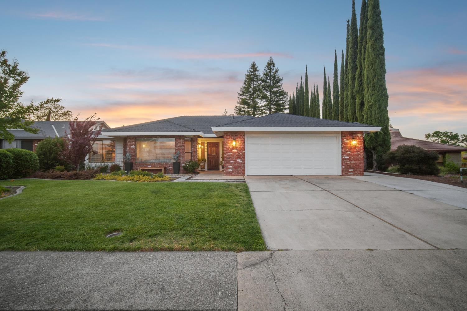 a front view of a house with a yard and potted plants