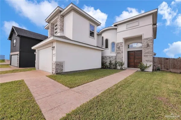 a view of a white house with a yard and garage