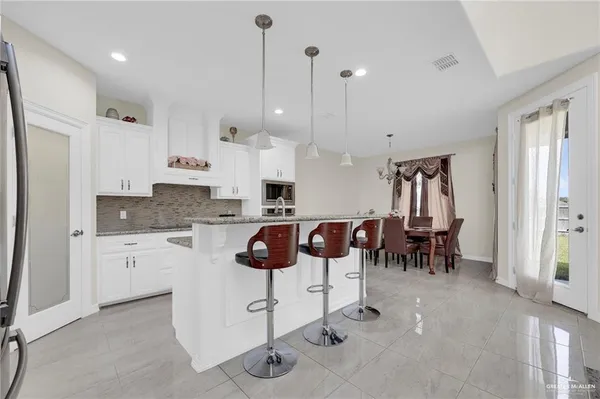 a kitchen with stainless steel appliances granite countertop a sink refrigerator and microwave