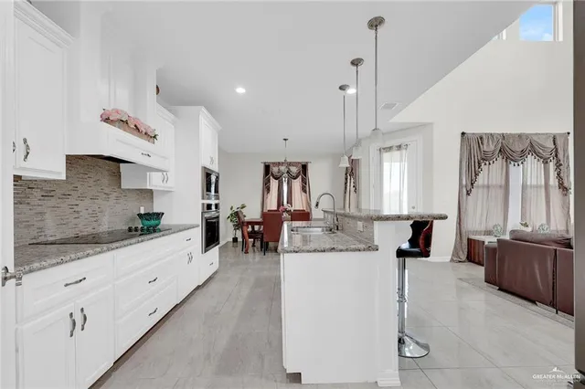 a kitchen with stainless steel appliances granite countertop a sink a stove a refrigerator and cabinets