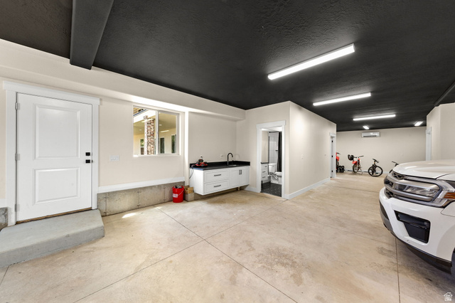 2591 East Washington Dam Road Washington, UT 84780 - Photo 55 of 67 Spacious garage featuring a dark ceiling, light-colored walls, concrete flooring, and multiple fluorescent light fixtures