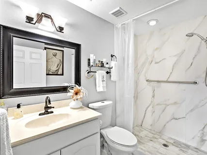 a bathroom with a sink vanity mirror and toilet