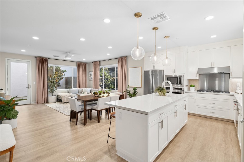 163 Tenor Irvine, CA 92618 - Photo 13 of 40 a large kitchen with kitchen island a sink a stove a dining table and chairs