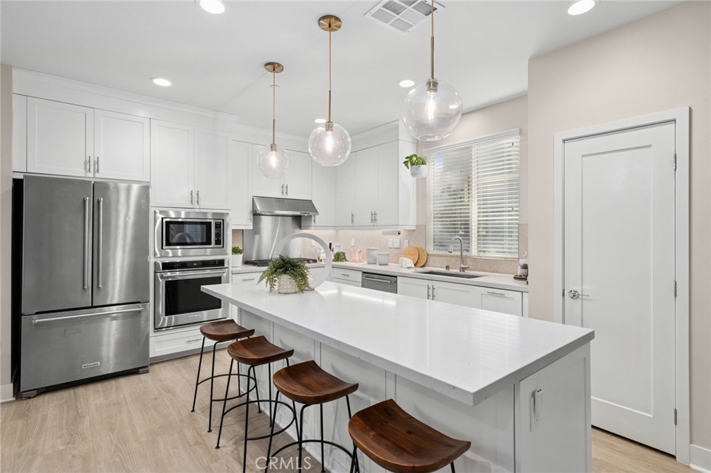 163 Tenor Irvine, CA 92618 - Photo 21 of 40 a kitchen with granite countertop a table chairs stove and refrigerator