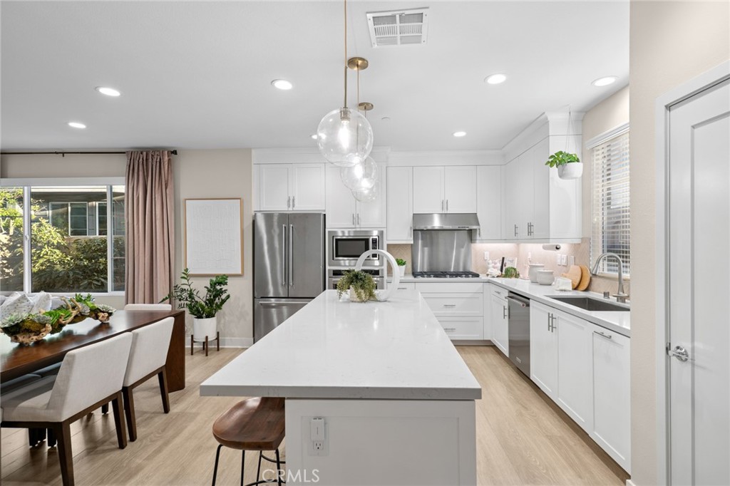163 Tenor Irvine, CA 92618 - Photo 24 of 40 an open kitchen with kitchen island white cabinets and stainless steel appliances