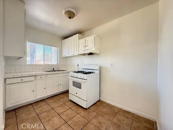 a kitchen with cabinets appliances and a window