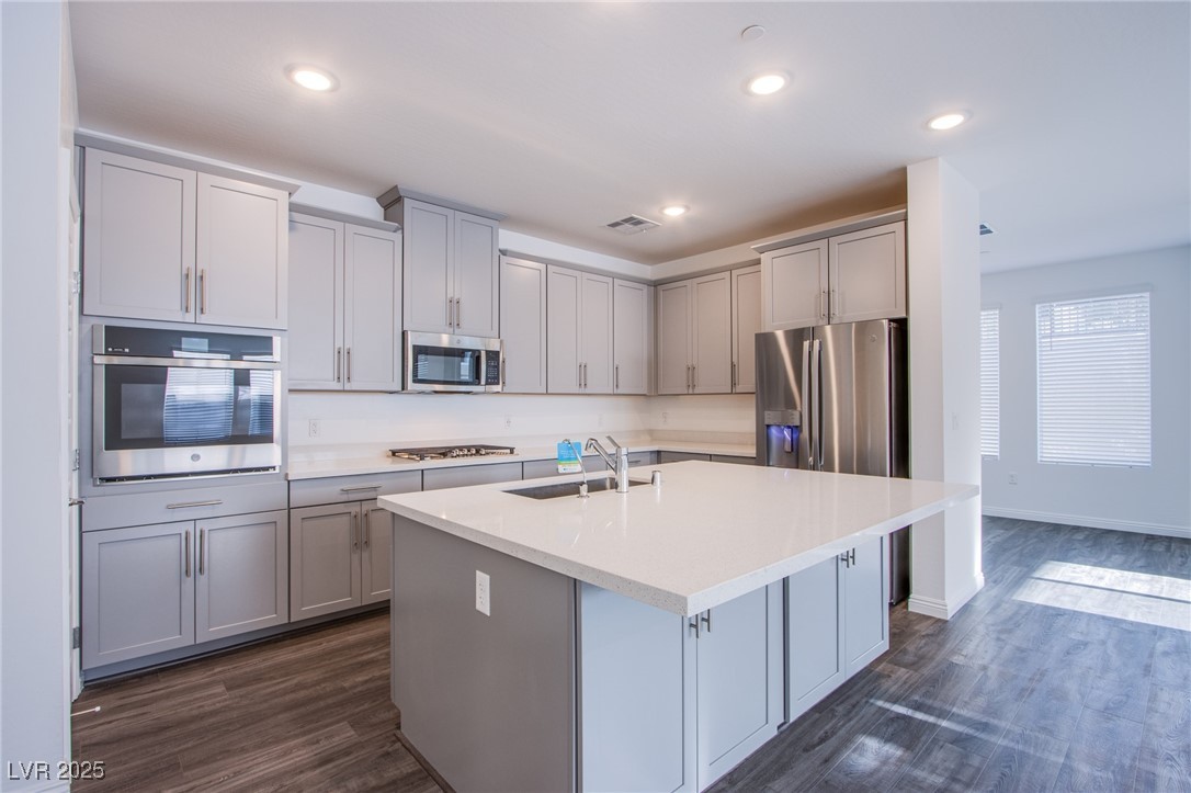 2555 Hampton Road, Unit 4109 Henderson, NV 89052 - Photo 5 of 38 Kitchen featuring stainless steel appliances, gray cabinets, dark wood finished floors, a kitchen island with sink, and recessed lighting