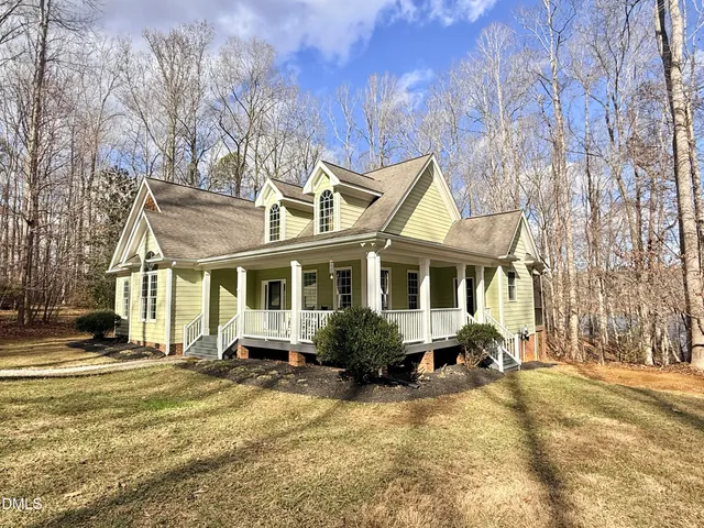 a front view of residential houses with yard and trees